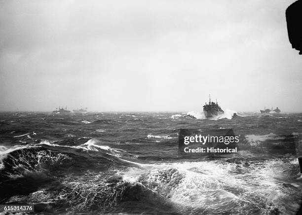 Ships travelling in convoy in the North Atlantic dot the horizon through rough seas. World War II.