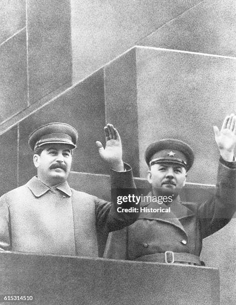 Joseph Stalin and Marshal Voroshilov reviewing troops in Red Square from the elevation of Lenin's Tomb.