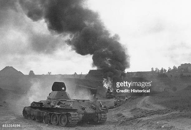 Soviet tanks battle the Germans in a battlefield in Jucourica[?]. One of the tanks in the background is burning. Ca. 1940s. | Location: Jucourica,...
