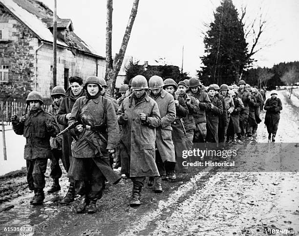 American prisoners captured during the Battle of the Bulge march under guard by German soldiers. Dec. 17, 1944