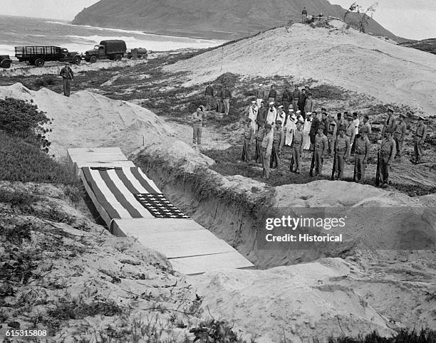 Military personnel pay their respects beside the mass grave of 15 officers and others killed in the bombing attack at Pearl Harbor on December 7,...