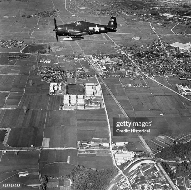 An F6F passes over the countryside of Kakogawa, Japan.