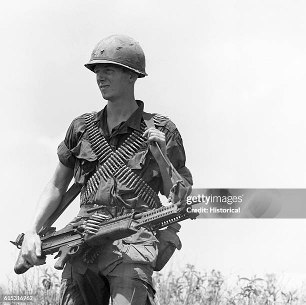 An American soldier carries an M-60 machine gun. Vietnam, 1968.
