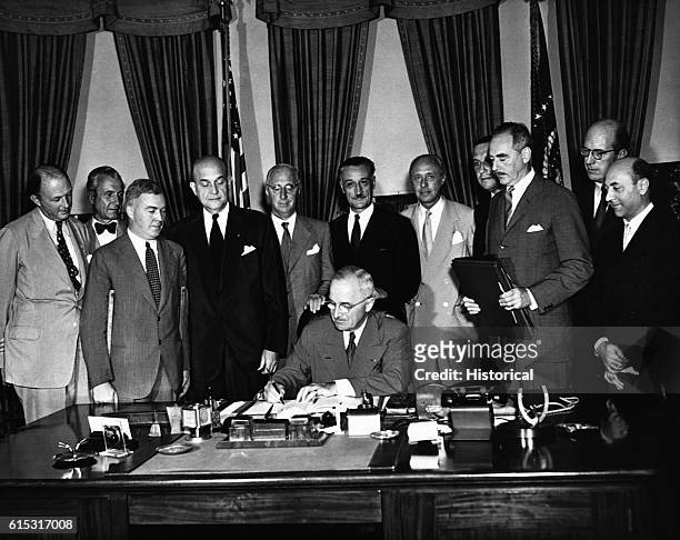 President Harry Truman signs the North Atlantic Pact creating the North Atlantic Treaty Organization as several foreign diplomats watch. August 24,...