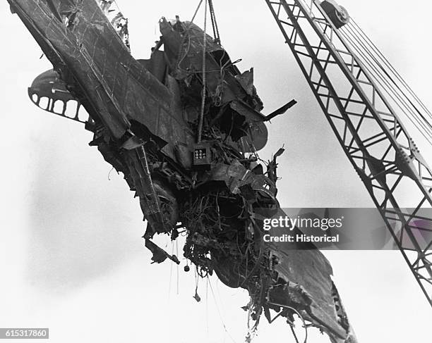 Crane lifts the mangled remains of a plane, a result of the Japanese attack on Pearl Harbor.