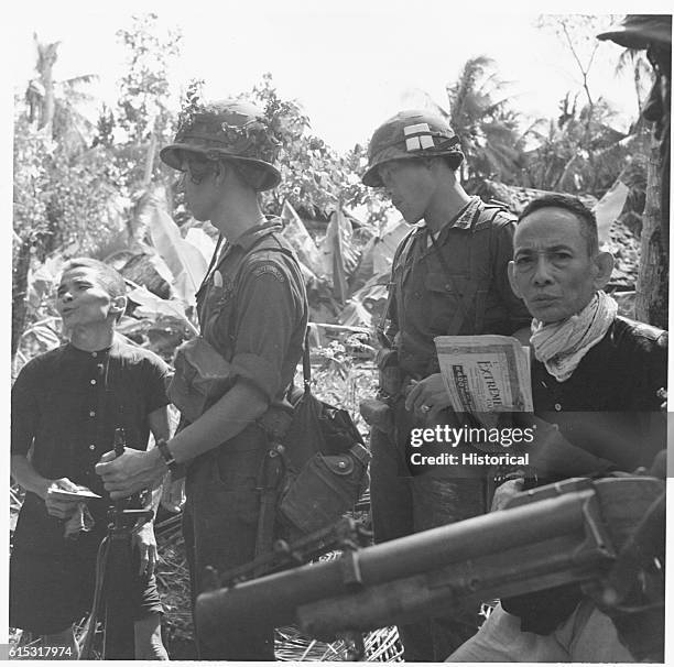 South Vietnamese soldiers examine the papers of some Vietcong[?]. Vietnam.