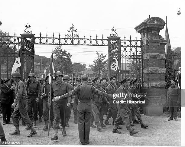 American and French soldiers march in Place General de Gaulle , Cherbourg, France.