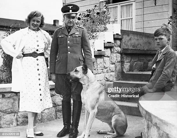 The commandant of the Buchenwald Concentration Camp, SS Colonel Karl Koch stands with his wife Ilsa their son and dog.