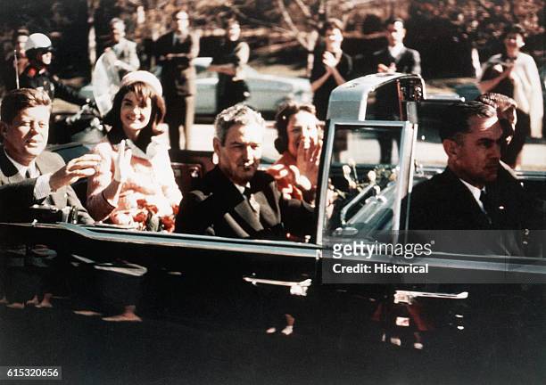 Prior to the assassination, President John F Kennedy, First Lady Jacqueline Kennedy, and Texas Governor John Connally ride through the streets of...