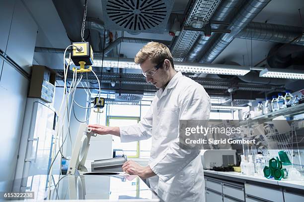 young male scientist working in a pharmacy laboratory, freiburg im breisgau, baden-württemberg, germany - centrifugal force stockfoto's en -beelden