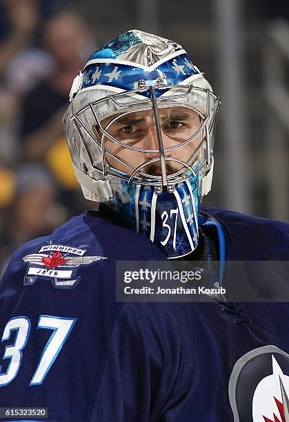 Goaltender Connor Hellebuyck of the Winnipeg Jets looks on during a first period stoppage in play against the Boston Bruins at the MTS Centre on...