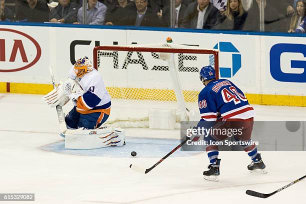 New York Rangers Right Wing Michael Grabner works towards an open net, as the puck deflects off New York Islanders Goalie Jaroslav Halak during the...