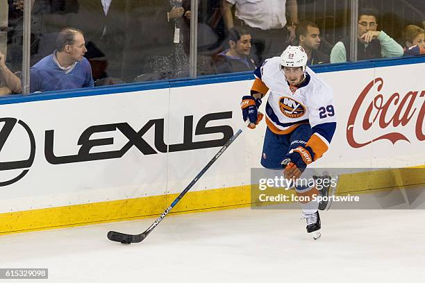 New York Islanders Center Brock Nelson skates with the puck along the boards during the first period of opening night at Madison Square Garden in a...