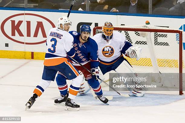 New York Islanders Denfenseman Travis Hamonic checks New York Rangers Left Wing Chris Kreider in front of New York Islanders Goalie Jaroslav Halak...
