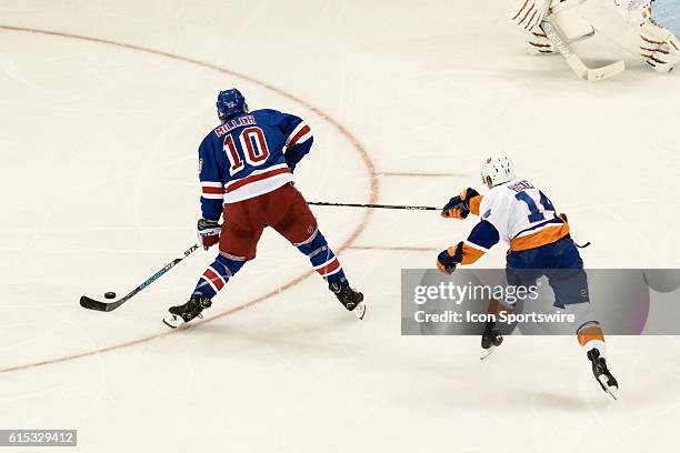 New York Islanders Denfenseman Thomas Hickey reaches out to distract New York Rangers Center J.T. Miller , as Miller works to the net, during the...