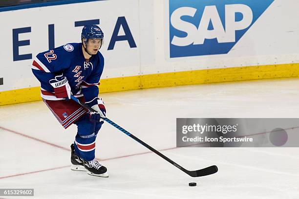 New York Rangers Defenseman Nick Holden looks to center the puck as he comes out from behind the net during the third period of opening night at...