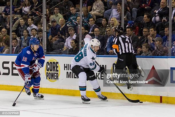 Referee Wes McCauley leaps out of the way of San Jose Sharks Right Wing Melker Karlsson as he works the puck around the net during the first period...