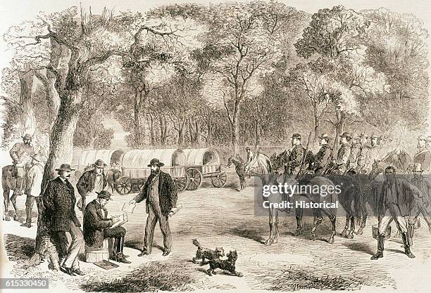 Jefferson Davis, President of the Confederate States of America, signs government papers by the roadside, surrounded by members of his cabinet, 1865.