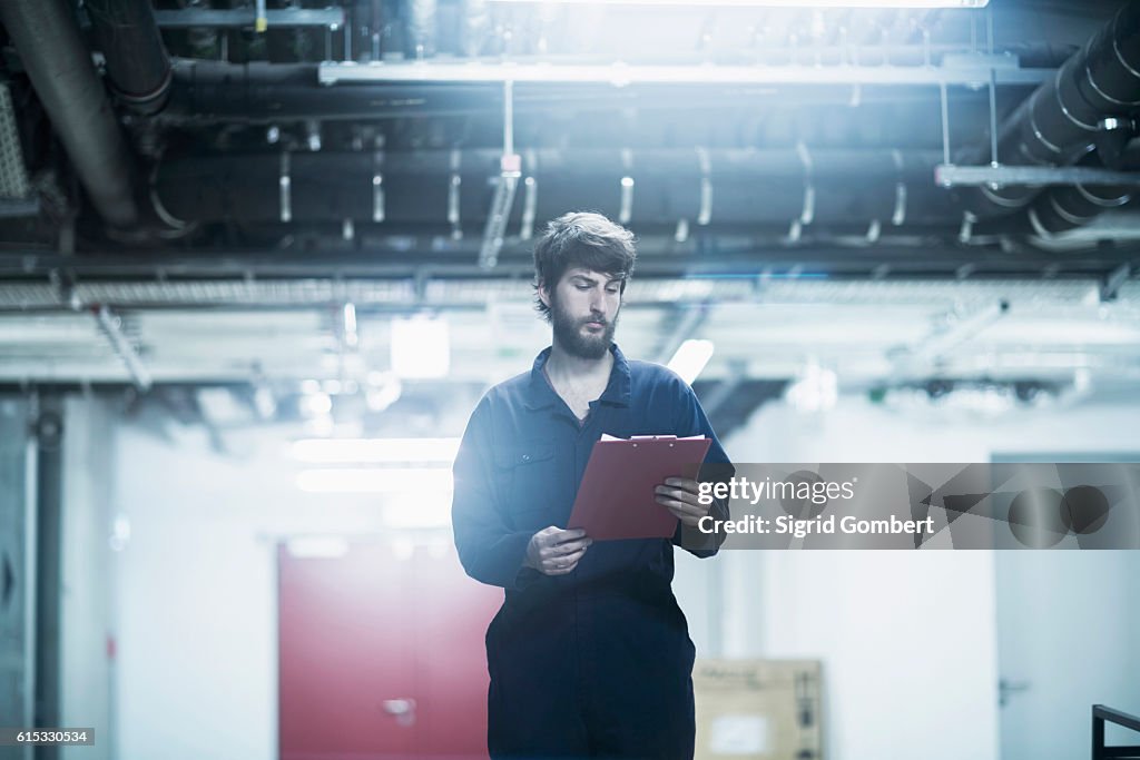 Young male engineer working in an industrial plant, Freiburg im Breisgau, Baden-Württemberg, Germany