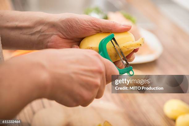 woman peeling potatoes with a potato peeler in kitchen, munich, bavaria, germany - peeler stock pictures, royalty-free photos & images