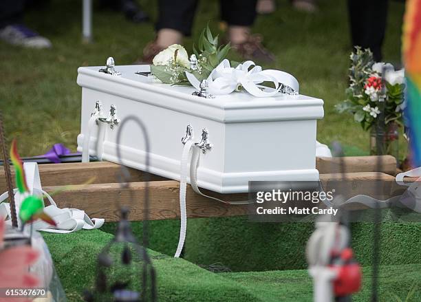 Mourners gather around the graveside for the funeral of a baby girl who was found dead on a footpath earlier this year at Wolvercote Cemetery on...