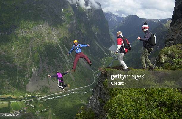 Four base jumpers leap out from "The Beak" at Gudvangen 27 June 2002 as extreme sport enthusiasts from all over the world are for the fifth year in a...