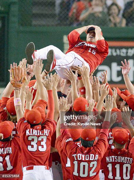 File photo taken in Tokyo in September 2016 shows Hiroshima Carp pitcher Hiroki Kuroda being thrown into the air after the team wins the Central...