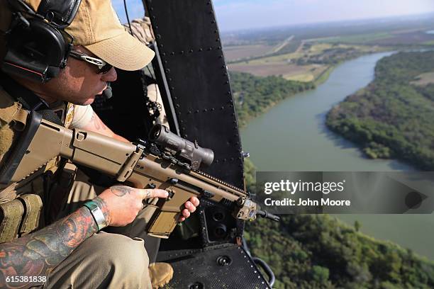 Customs and Border Protection agent scans the Rio Grande on the U.S.-Mexico border on October 18, 2016 in McAllen, Texas. U.S. Air and Marine...