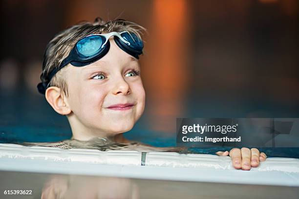 porträt eines kleinen jungen im swimmingpool - learning to swim stock-fotos und bilder
