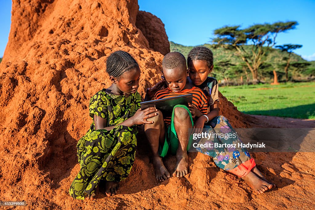 Little African children using digital tablet, East Africa