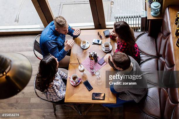 elevated view of friends in cafe - double date stock pictures, royalty-free photos & images