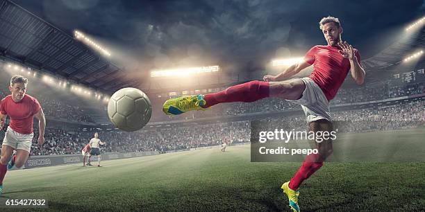 soccer player in mid air volley action during football match - soccer striker stockfoto's en -beelden