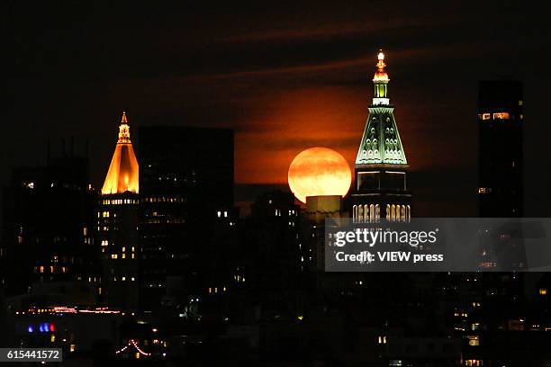 Full Hunter's super moon rises behind middle Manhattan and Empire State Building in New York City on October 16, 2016 as seen from Hoboken, NJ,