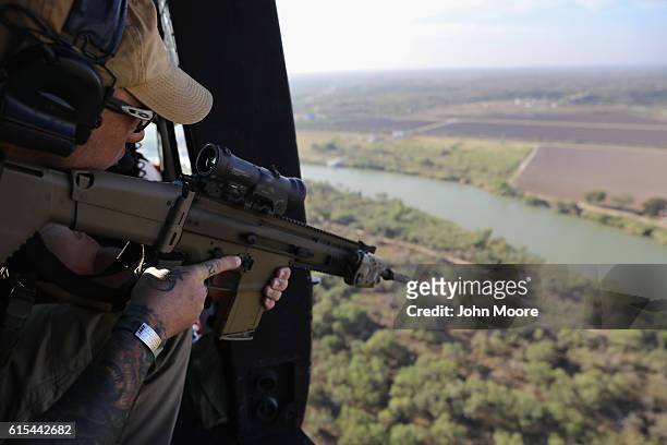 Customs and Border Protection agent scans the U.S.-Mexico border from a helicopter patrol on October 18, 2016 near McAllen, Texas. U.S. Air and...