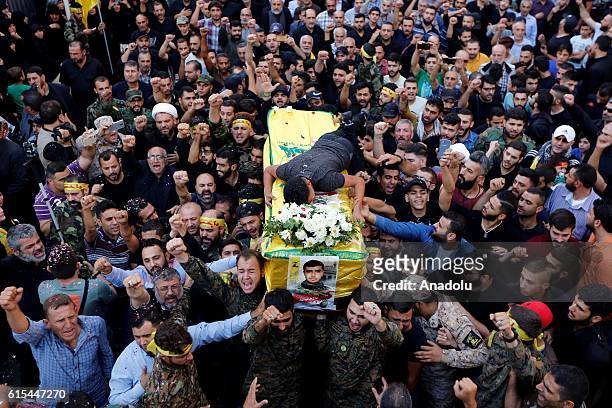 People carry the coffin of member of Hezbollah Hatem Hamadi, during a funeral ceremony at Dahieh district of Beirut in Lebanon on October 18, 2016.