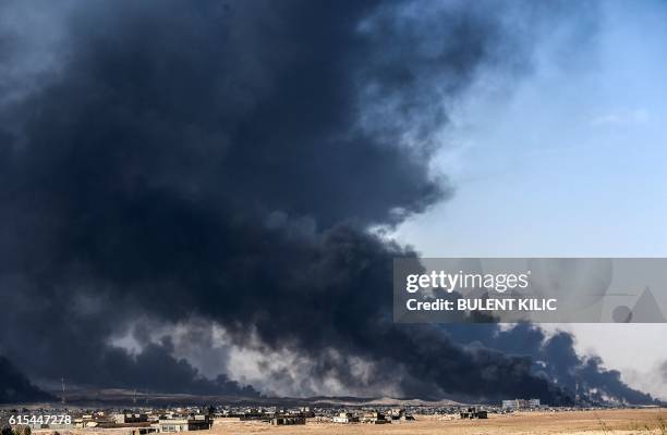 Smoke rises from burning oil wells on October 18, 2016 near the town of Qayyarah, south of Mosul, during the operation to recapture the city from the...