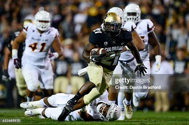 Colorado Buffaloes running back Kyle Evans rushes and avoids a tackle attempt by Arizona State Sun Devils linebacker Marcus Ball at Folsom Field on...
