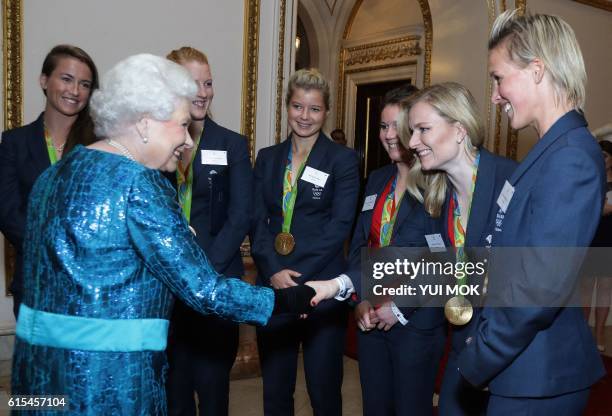 British Olympic womens hockey team player Hollie Webb reacts as she shakes hands with Britain's Queen Elizabeth II, during a reception for Team GB's...