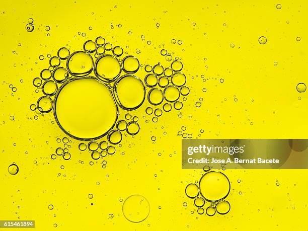 full frame of circular bubbles floating on water yellow - oil abundance stock pictures, royalty-free photos & images