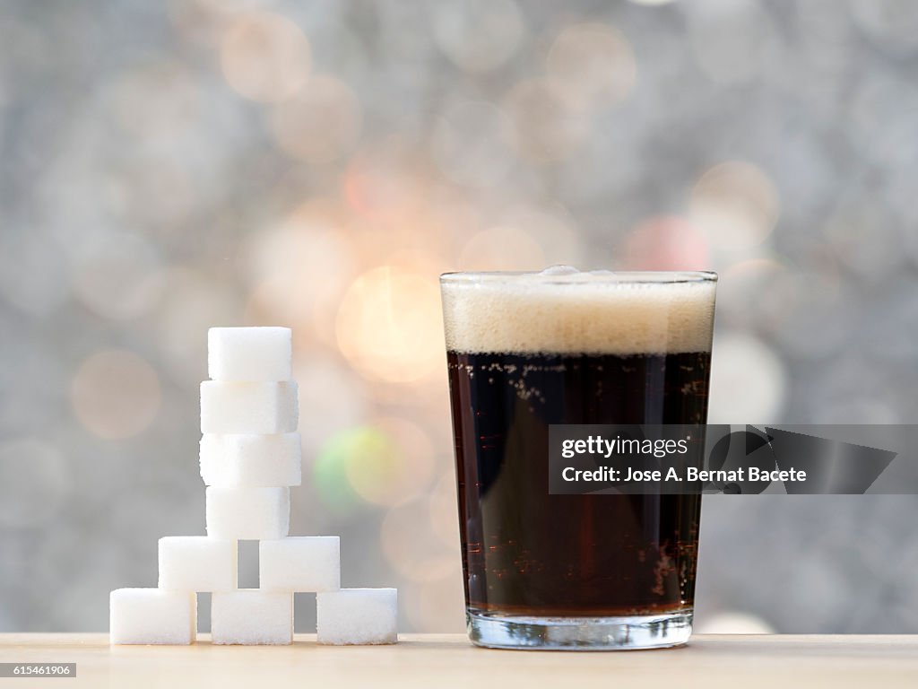 Glass with cola and its equivalent in sugar cubes