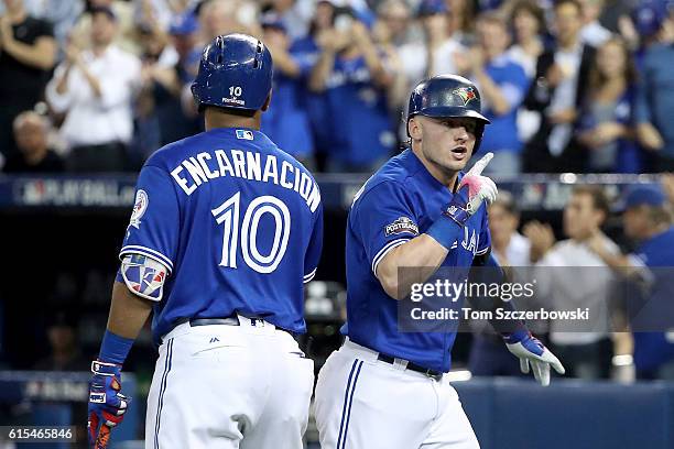 Josh Donaldson of the Toronto Blue Jays celebrates with teammate Edwin Encarnacion after hitting a solo home run in the third inning against Corey...