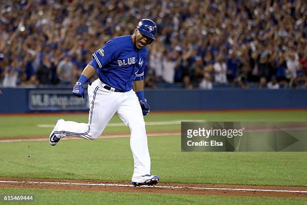 Edwin Encarnacion of the Toronto Blue Jays celebrates after hitting an RBI double scoring Ryan Goins and Jose Bautista in the seventh inning against...