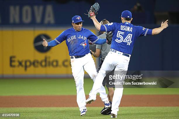 Ezequiel Carrera and Roberto Osuna of the Toronto Blue Jays celebrate after defeating the Cleveland Indians with a score of 5 to 1 in game four of...