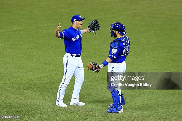 Roberto Osuna and Russell Martin of the Toronto Blue Jays celebrate after defeating the Cleveland Indians with a score of 5 to 1 in game four of the...