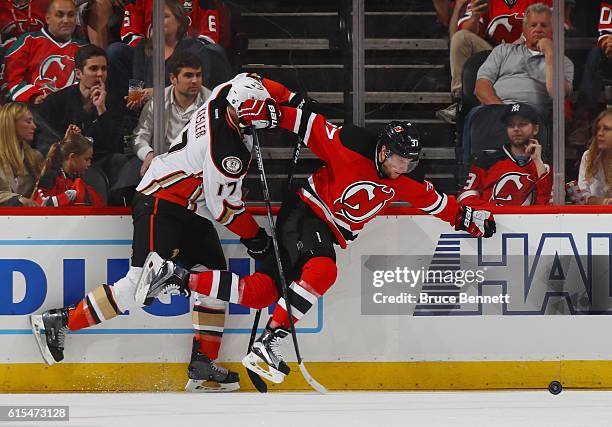 Pavel Zacha of the New Jersey Devils is tripped up by Ryan Kesler of the Anaheim Ducks during the first period at the Prudential Center on October...