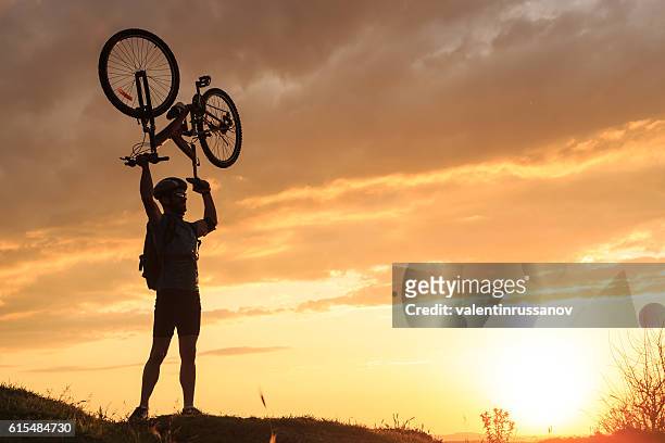 junger sportler hebt sein fahrrad - bike headset stock-fotos und bilder