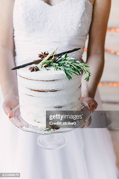 bride holding a craft cake on a glass stand