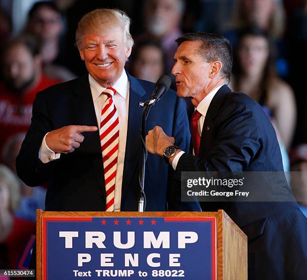 Republican presidential candidate Donald Trump jokes with retired Gen. Michael Flynn as they speak at a rally at Grand Junction Regional Airport on...