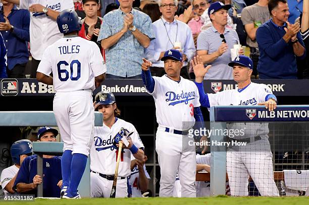 Manager Dave Roberts points at Andrew Toles of the Los Angeles Dodgers after he scores a run in the third inning on a hit by Corey Seager against the...