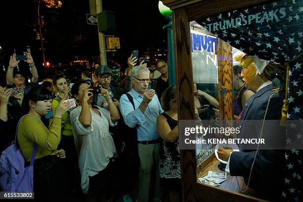 People view the art installation "All-Seeing Trump", a fortune telling machine created by a group of anonymous Brooklyn-based artists, outside the...